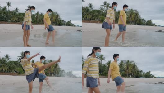 快乐的亚洲孩子们一起在沙滩上踢水嬉水，生活理念。高清在线视频素材下载