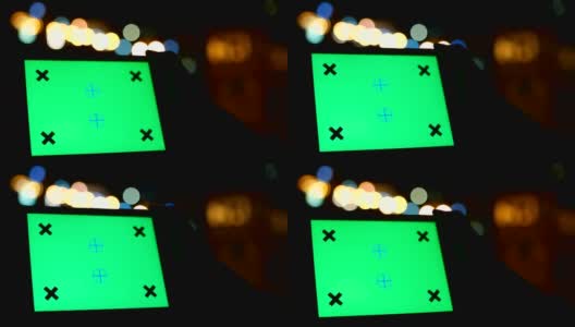 使用绿色屏幕的数字平板电脑与夜间交通灯背景的特写镜头高清在线视频素材下载