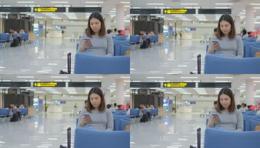 一名女乘客在离港机场办理登机手续前，用手机在数字登机牌上检查她的航班高清在线视频素材下载