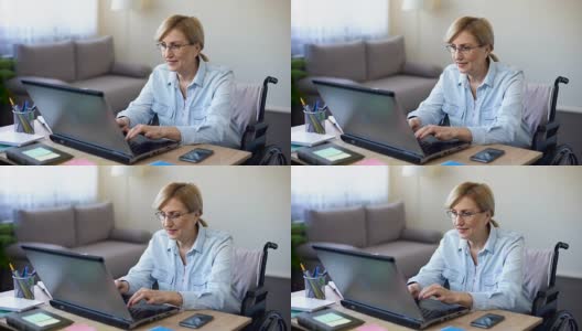 轮椅上的成功资深女性用笔记本电脑工作，和客户聊天高清在线视频素材下载