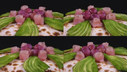 披萨有鳄梨，葡萄和装饰火腿像玫瑰一样旋转高清在线视频素材下载