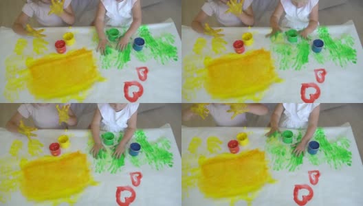 幸福家庭油漆颜色。近距离的快乐的小可爱的孩子的手在纸上画彩色的图画。一个可爱快乐有趣的小女孩画颜色，慢镜头高清在线视频素材下载