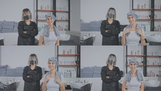 肖像亚洲职业女性造型师双手交叉，戴口罩和面罩以防止冠状病毒感染，站在年轻的白人顾客坐在沙龙洗床高清在线视频素材下载