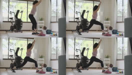 健康的妈妈在家锻炼，而她的宝宝在玩耍高清在线视频素材下载