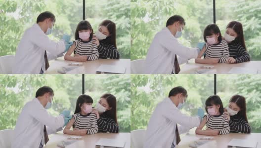 感受少女对针头的恐惧，亚洲资深男医生戴着卫生口罩在亚洲患者的手臂上注射疫苗，一个孩子带着姐姐像朋友一样过来高清在线视频素材下载