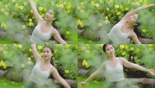 年轻的亚洲女人在花园里练习瑜伽。女性的幸福。模糊的背景。健康的生活方式和放松的观念。年轻的亚洲女孩在公园里做瑜伽。高清在线视频素材下载