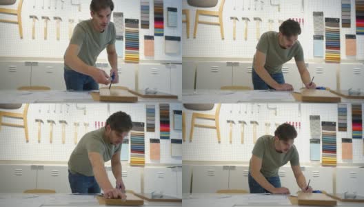 男设计师在办公室画一些草图并测量一块木板高清在线视频素材下载