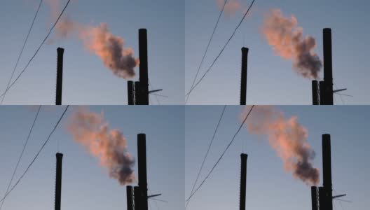 夕阳下，从工业烟囱、锅炉房或工厂冒出的红色烟雾。能源生产和污染环境的工业生产。高清在线视频素材下载