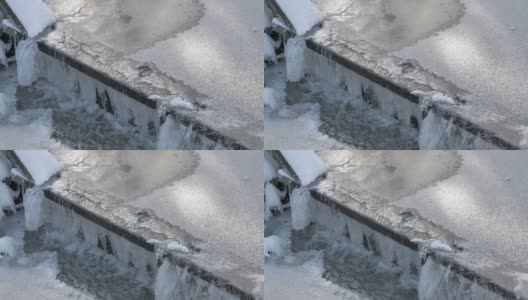这是一张可怕的照片，冬天结冰的水流过一个小水坝。高清在线视频素材下载