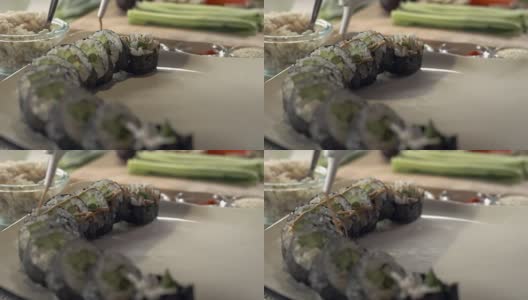 寿司师傅将辣味蛋黄酱淋在新鲜的寿司卷上高清在线视频素材下载