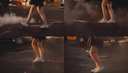 在纽约市中心，一个年轻女子在晚上使用智能手机过马路的特写高清在线视频素材下载