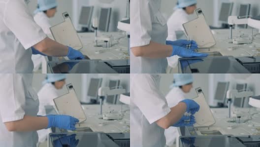 护士在现代化的实验室里用专用机器做了测试后取瓶样本。高清在线视频素材下载