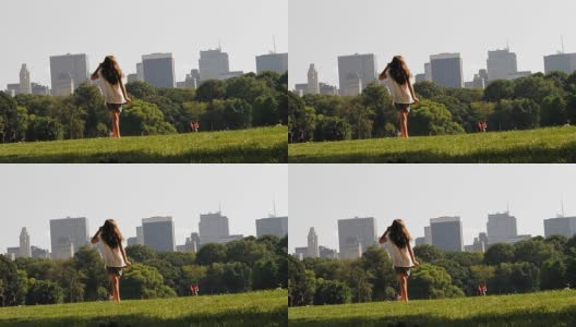 曼哈顿中央公园。以摩天大楼为背景的草地景观。一个小女孩在一张照片上用慢镜头走着高清在线视频素材下载