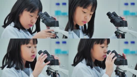 理科学生在学校实验室里看显微镜。教师和好奇的学生在教室实验室进行科学实验。教育、技术、团队、科学、人本理念。教育的主题高清在线视频素材下载