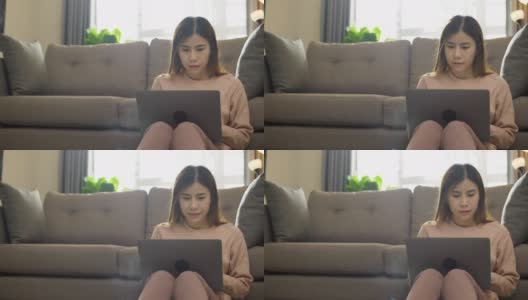 坐在沙发上使用笔记本电脑的女人高清在线视频素材下载