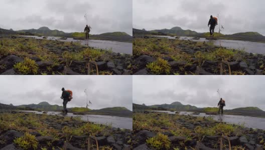 一个年轻人从冰岛的兰德马纳洛格尔出发，在54公里的长途跋涉中穿过山谷中的一条河高清在线视频素材下载