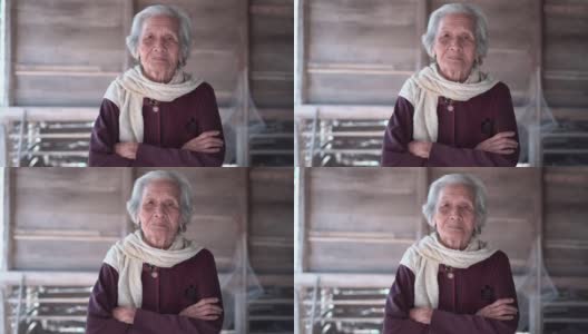 亚洲老年妇女的肖像，年长的妇女与短灰色头发站在交叉的胳膊和看相机，老年妇女的概念高清在线视频素材下载