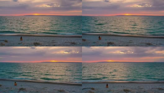 一个女人坐在海边看日落高清在线视频素材下载