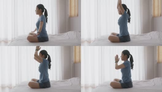 亚洲人早起健康生活平衡的好处瑜伽姿势在床上。高清在线视频素材下载
