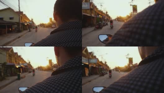 在美丽的日落时分，一名游客驾驶摩托车在热带岛屿上旅行。slowmotion。泰国。帕,1920 x1080高清在线视频素材下载