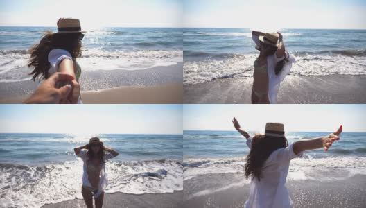 年轻女子拉她的男朋友在海边享受暑假或假期。戴着帽子的女孩牵着男人的手在海滩上奔向大海。自由的概念。慢镜头高清在线视频素材下载