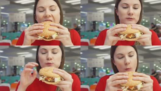 饥饿的女孩在美食广场吃汉堡。在快餐店里咬着芝士汉堡的女人高清在线视频素材下载