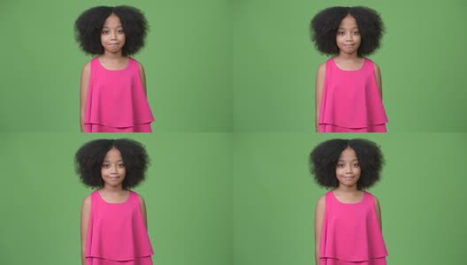 年轻可爱的非洲女孩在绿色背景下有着非洲式的头发高清在线视频素材下载