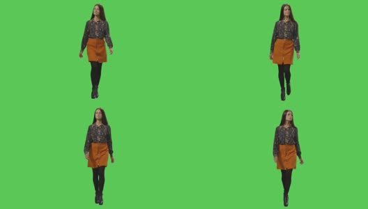随便年轻的黑发女孩走在一个模型的绿色屏幕在背景。高清在线视频素材下载