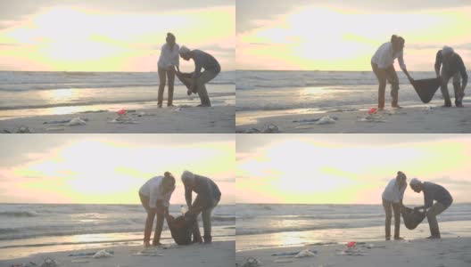 一对亚洲老夫妇用装满垃圾的塑料袋清理海滩。缓慢的运动。生态安全概念。4 k决议。高清在线视频素材下载