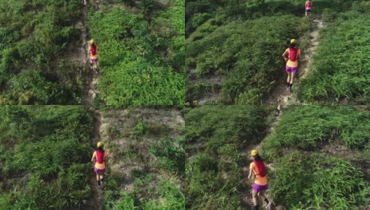 两名女性朋友在热带雨林的山坡上跑超级马拉松的鸟瞰图，4k高清在线视频素材下载