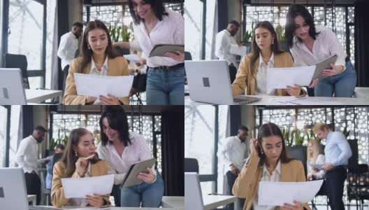 迷人的年轻女商人在现代办公室里与财务报告和平板电脑一起工作高清在线视频素材下载