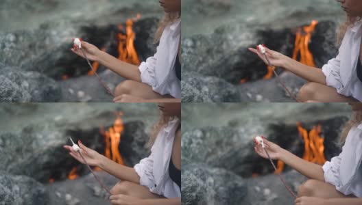 女士在奇迈拉山火上挂棉花糖高清在线视频素材下载