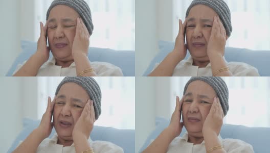 一位戴着头巾的患癌症的老妇人躺在医院的病床上，她感到头痛。高清在线视频素材下载