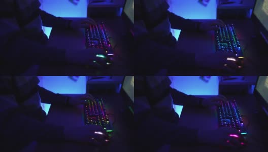 用蓝色霓虹灯照亮的暗室，懒人日夜玩在线游戏。特写的人的手指点击电脑键盘与光谱背光照明。视频网络空间和娱乐概念高清在线视频素材下载