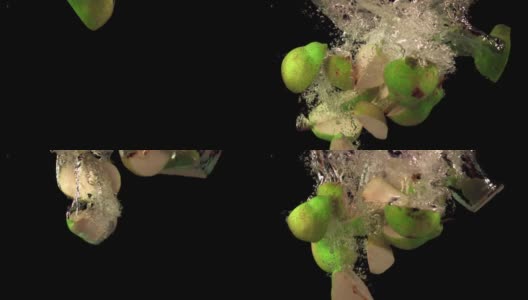 超级慢镜头，熟透的梨子带着气泡掉进水里。用高速摄像机以每秒1000帧的速度拍摄。高清在线视频素材下载