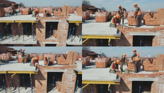工人们正在砌红砖盖房子。建筑工人们正在为一座高层建筑建造砖墙高清在线视频素材下载