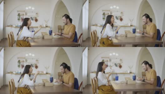 一对亚洲年轻夫妇在客厅的桌子上享受着外卖高清在线视频素材下载