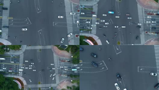 无人机拍摄的城市十字路口，汽车和公交车行驶在大道上。在日落时分。相机移动。高清在线视频素材下载