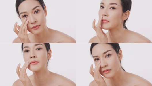 亚洲美丽的女人在白色的背景上使用面霜。高清在线视频素材下载