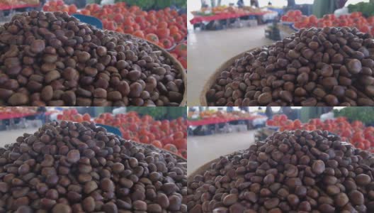 市场上成堆的可食用栗子。栗子和其他水果在乡村市场高清在线视频素材下载