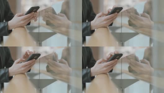 一个女人的手触摸手机的特写，模糊的背景。现代人的生活方式是用手机高清在线视频素材下载