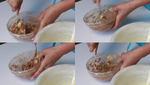 一位妇女用可可粉揉面团来准备大理石蛋糕。高清在线视频素材下载