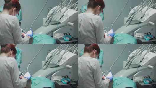 牙医和护士正在给一个病人补牙。用bormashenko钻牙，清除蛀牙和密封高清在线视频素材下载