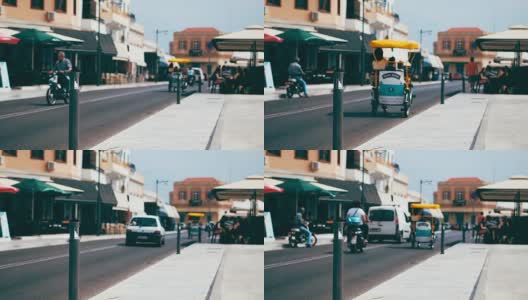 三轮车在这个欧洲度假小镇的道路上穿梭于汽车和摩托车之间高清在线视频素材下载