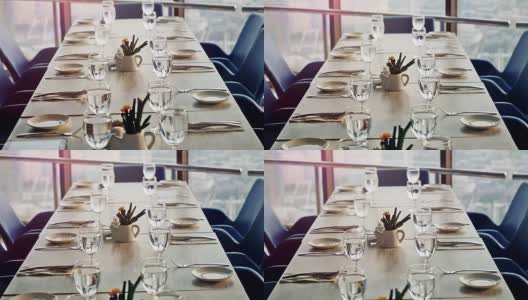 宴席装饰餐桌，用刀叉。近距离的优雅，装饰桌子准备一个豪华的晚餐在日落时间的窗户。缓慢的运动。1920 x1080高清在线视频素材下载