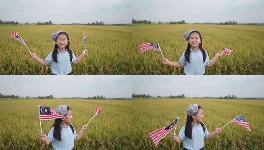 马来西亚独立日当天，一名亚洲华裔女孩在操场上挥舞着马来西亚国旗，享受着清晨的阳光，感到自豪和快乐高清在线视频素材下载