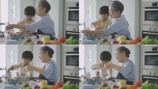 亚洲华人奶奶在厨房教孙子烘焙高清在线视频素材下载