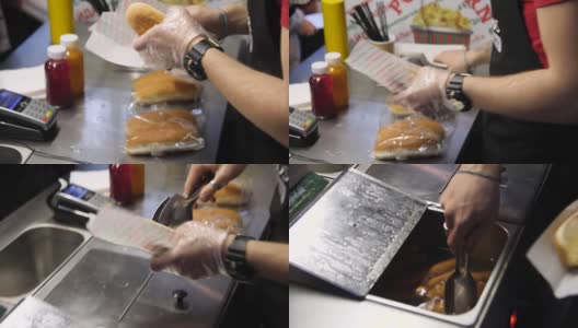 咖啡馆里，一名男子把美味的香肠放进新鲜的小面包里做热狗高清在线视频素材下载