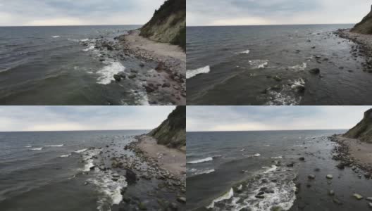 在刮风寒冷的日子里，海浪和石头的岩石被无人机拍摄下来高清在线视频素材下载