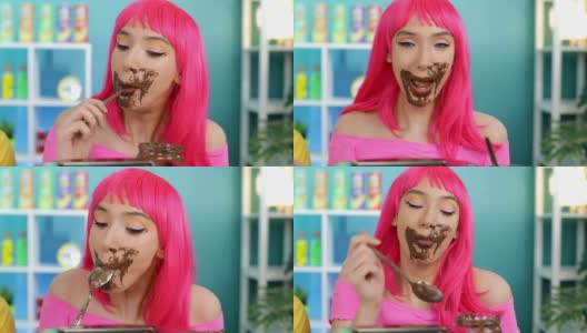 一个粉红色头发的女孩贪婪地用勺子吃巧克力高清在线视频素材下载